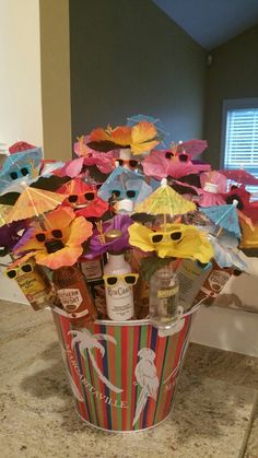 a bucket filled with lots of colorful umbrellas on top of a counter next to a sink