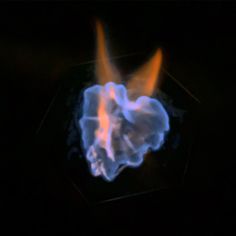 a heart shaped object in the dark with fire coming out of it's center