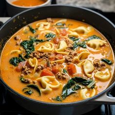 a pot filled with pasta and spinach soup