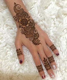 a henna tattoo on the hand of a woman