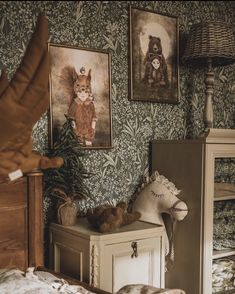 a bedroom with pictures on the wall and stuffed animals sitting on top of dressers