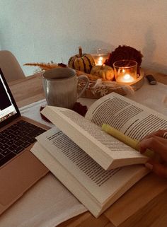 an open book sitting on top of a table next to a laptop computer