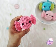 two small crocheted elephants sitting next to each other in front of a bowl