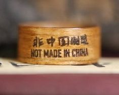 a wooden ring that says not made in china on top of a book with chinese writing