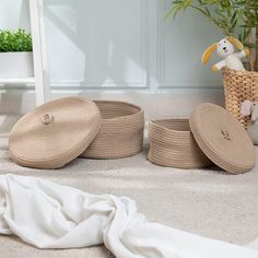 four woven baskets and a stuffed animal on the floor