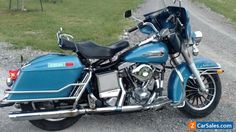 a blue motorcycle parked on top of a gravel road