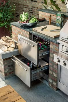 an outdoor kitchen with stainless steel appliances and counter space for cooking food on the grill