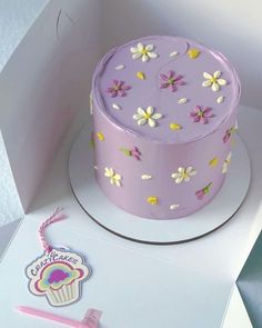 a purple cake sitting on top of a white box