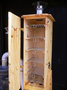 a wooden cabinet with several shelves and hooks