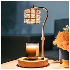 a table lamp sitting on top of a wooden table next to a vase with flowers