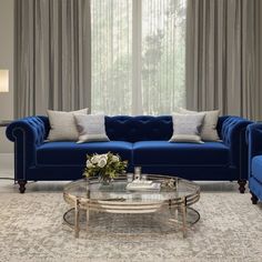 a living room filled with blue couches next to a window covered in drapes