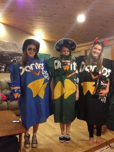 three women in costumes standing on a wooden floor