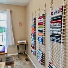 the wall is filled with many different types of fabrics and sewing supplies on display next to a window