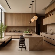 a large kitchen with wooden cabinets and counter tops, along with bar stools that sit on the floor