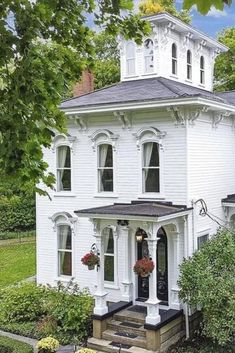 a large white house sitting on top of a lush green field