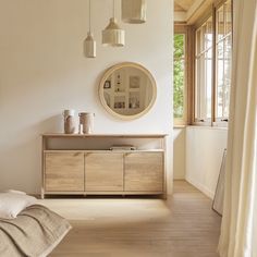 a bedroom with white walls and wooden furniture