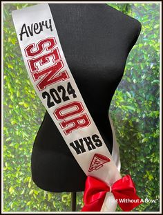 a red and white ribbon on top of a mannequin