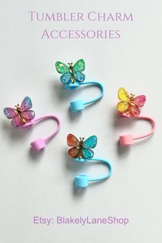 four colorful butterfly hair clips on a white background with the words tumbler charm accessories