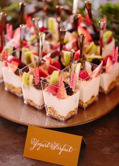 small desserts are arranged on a wooden platter