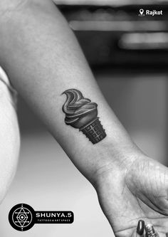 a woman's arm with a tattoo on it that is shaped like an ice cream cone