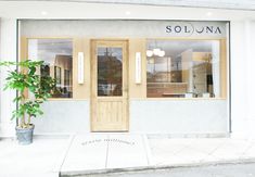 the front entrance to soluna salon with potted plant