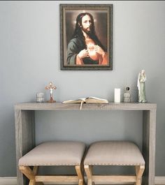 two stools in front of a table with a painting on the wall above it