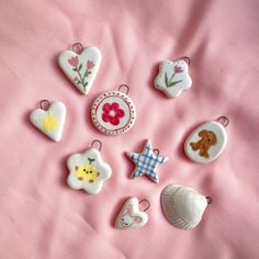 some little buttons are laying on a pink sheet with flowers and other things to sew