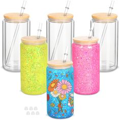 four jars with wooden lids and colorful glitters on them, one has a straw in the lid