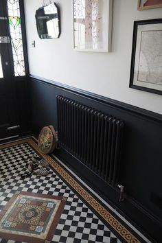 a black and white checkered floor with a radiator in the corner next to it