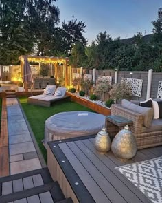 an outdoor living area is lit up with lights and seating for the guests to sit on