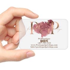 a person holding up a business card with pink flowers on the front and back of it