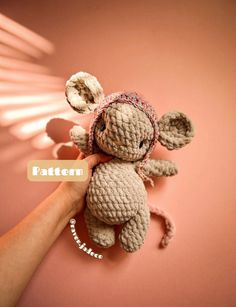 a small crocheted stuffed animal is being held by a person's hand