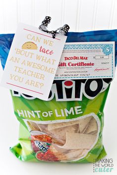 a bag filled with chips sitting on top of a white table next to a sign