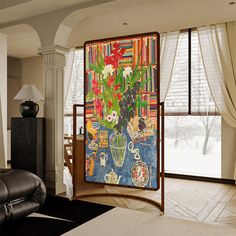 a living room filled with furniture and a large painting hanging on the side of a wall