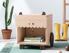 a wooden toy car sitting on top of a rug next to a potted plant