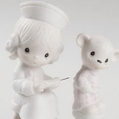 two white figurines are standing next to each other