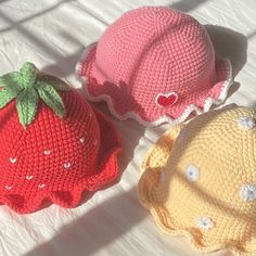 three crocheted strawberries sitting on top of a bed