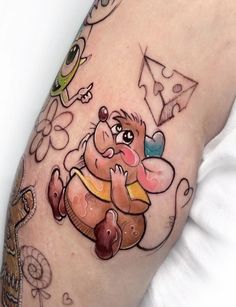 a cartoon character tattoo on the right side of the arm, with other characters around it