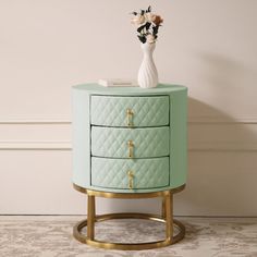 a green and gold nightstand with flowers on top