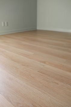 an empty room with hard wood floors and white walls