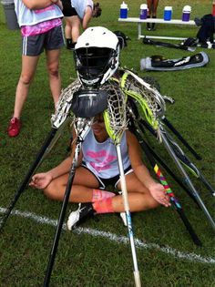 a woman sitting on the ground with some skis and poles in her lap,