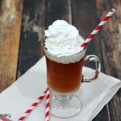 there is a drink with whipped cream on top and two red and white striped straws