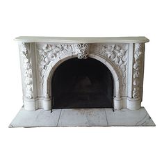 a white marble fireplace with an ornate design on the mantle and bottom, against a white background