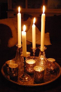 candles are lit on a tray in the dark