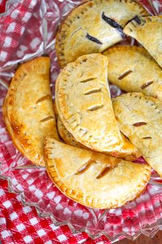 some pies are sitting on a red and white checkered cloth in a bowl