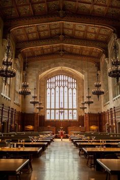 the inside of a large building with tables and chandeliers hanging from the ceiling