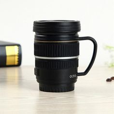 a camera lens coffee mug sitting on top of a table