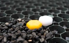 two eggs sitting on top of some black rocks