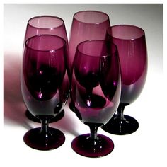 four wine glasses sitting next to each other on a table