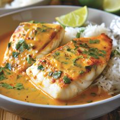 two pieces of fish on top of rice and garnished with cilantro